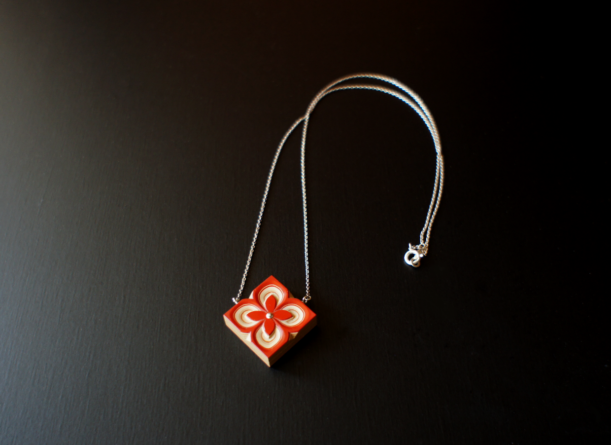 it's a tsuishitsu pendant. It is a carved board made of urushi coated more than 100 times.