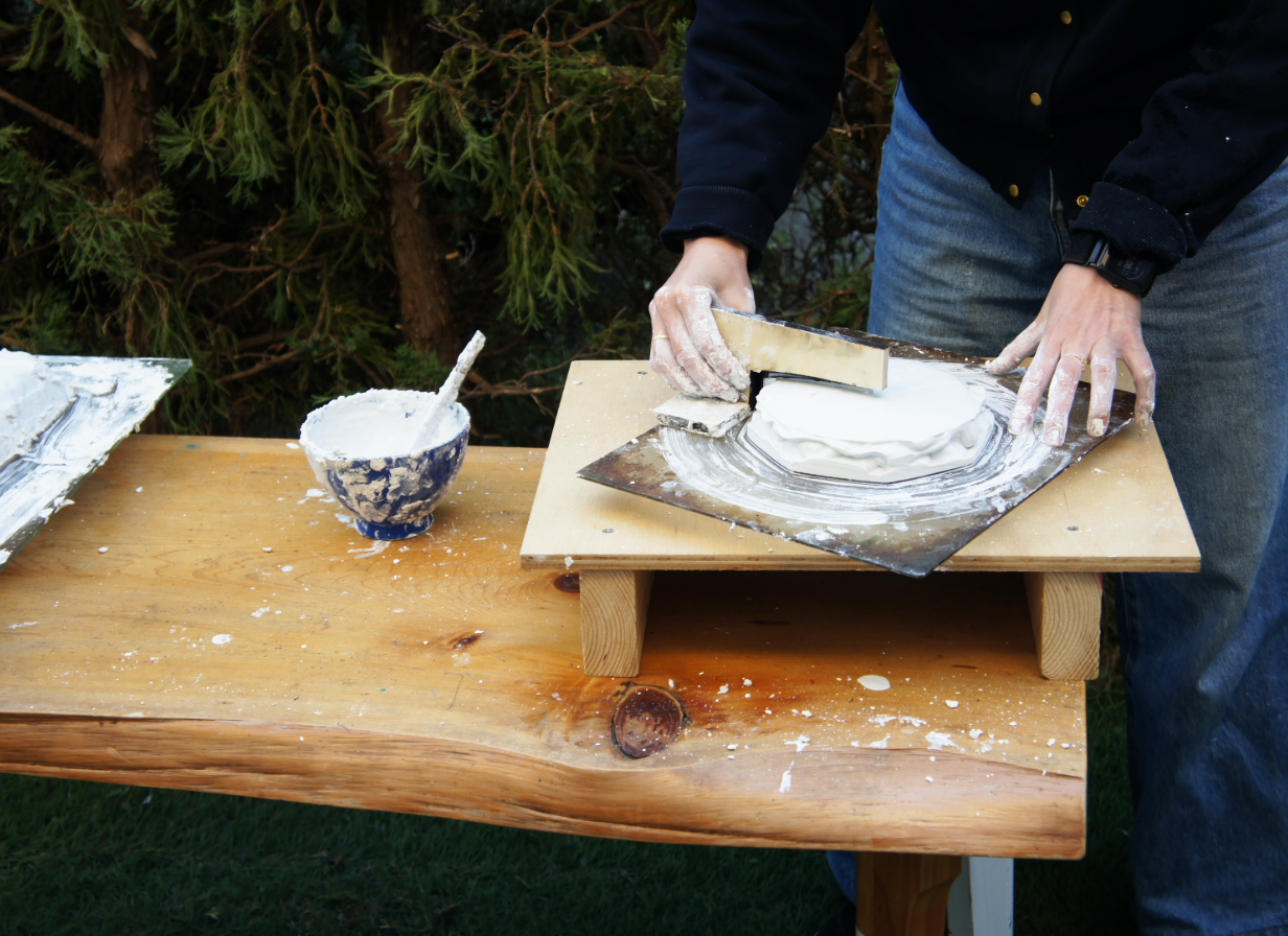 On the rotating table, the glass plate, the acrylic bottom plate, and the styrofoam inside, in that order. Plaster is then poured from the top.